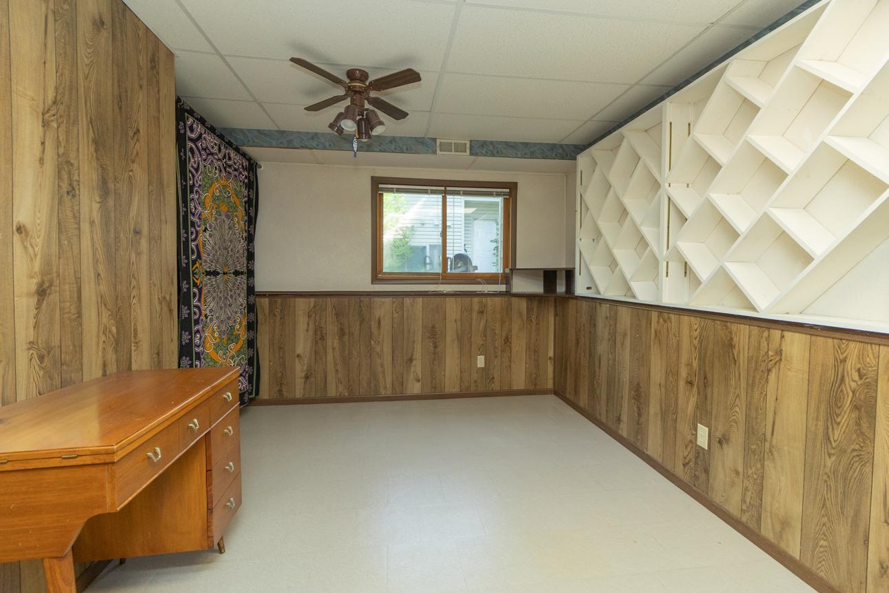 Current owner has transformed this LL 13x10 bedroom into a craftsperson's dream, featuring custom-built fabric or yarn cubbies.