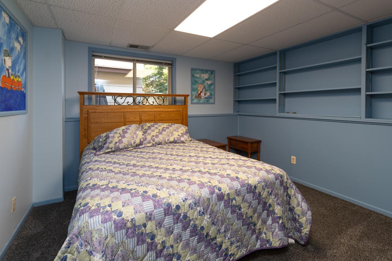 This lower-level 12x11 bedroom has built-in shelves.