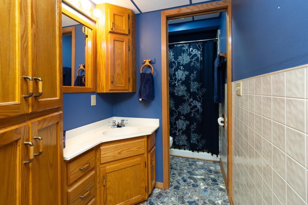 Lower-level 3/4 bath with pocket door to shower and toilet. Big linen storage.