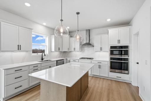 (All the following photos are of a similar home, actual finishes may vary.) This stylish kitchen showcases a large center island, Shaker-style cabinetry, and brand-new stainless-steel appliances.
