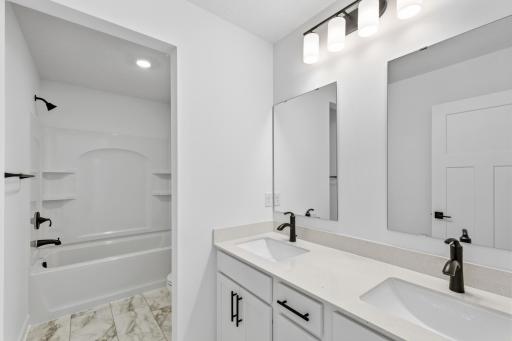 This full bathroom is conveniently located on the second floor and showcases dual sinks and a shower-tub combination.