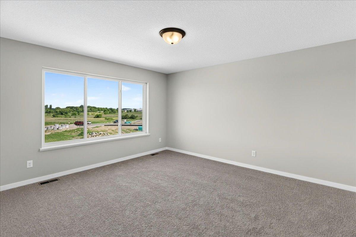 PHOTO OF A DIFFERENT HOME WITH SIMILAR PLAN & FINISHES. Primary Suite.