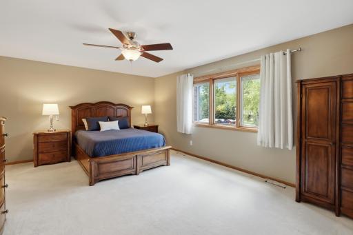 Spacious primary bedroom featuring large windows and peaceful surroundings