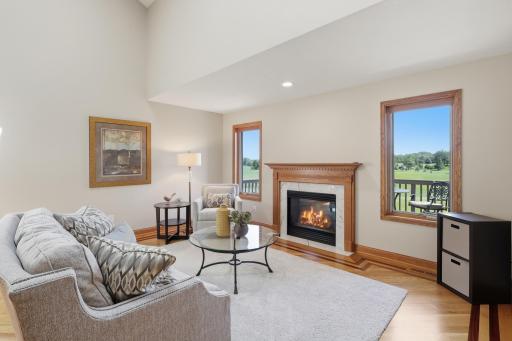 Expansive living room highlighted by abundant natural light and panoramic golf course views.