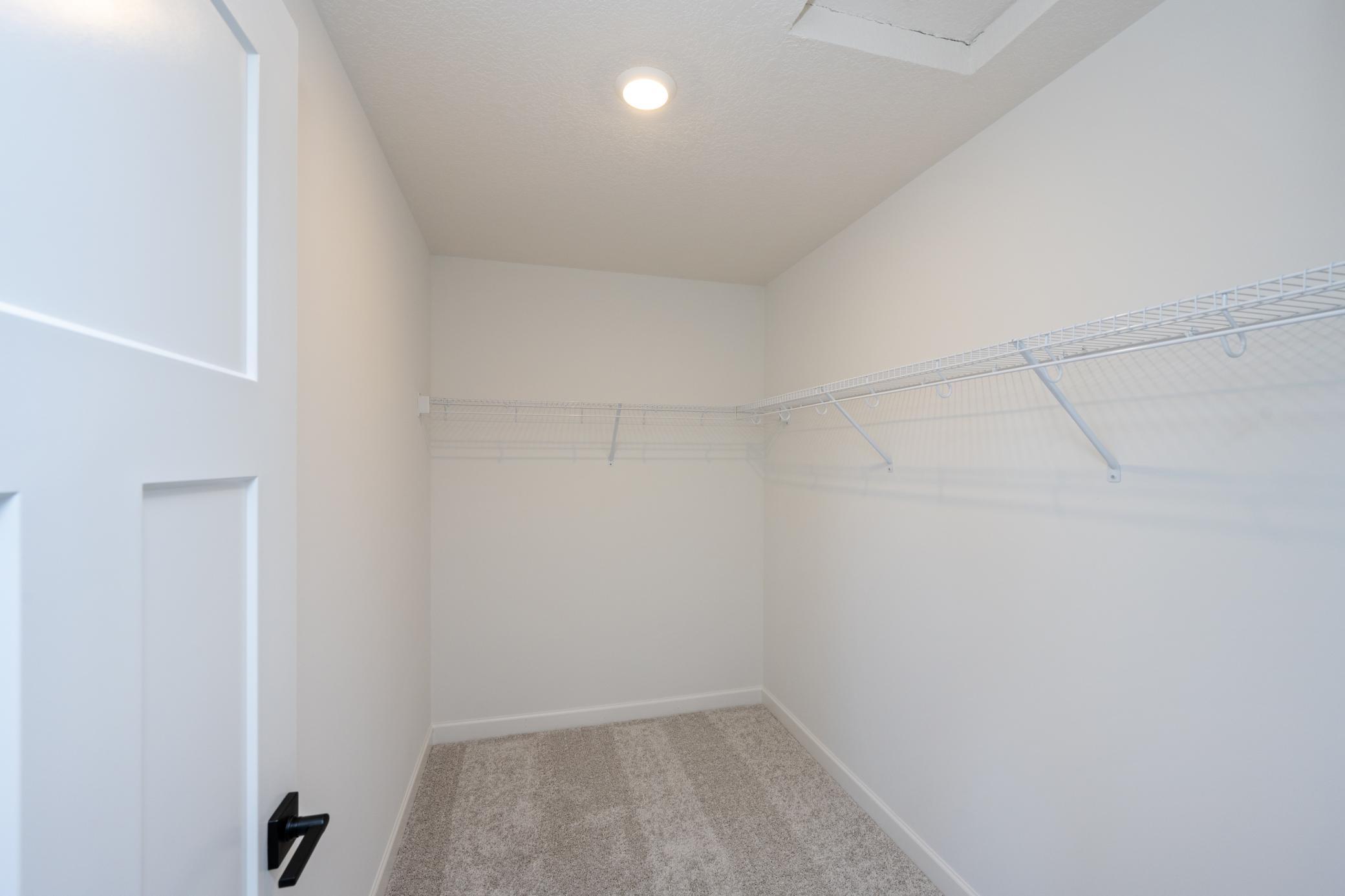 (Photo of a similar home, actual finishes may vary) The walk-in closet in the primary bedroom