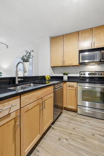 Updated kitchen featuring granite countertops, stainless steel appliances, and ample cabinetry.