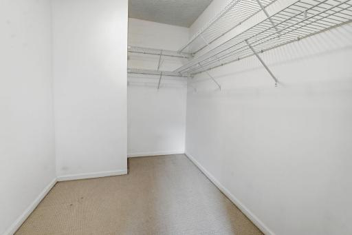 Walk-in closet with built-in shelving for additional organized storage.