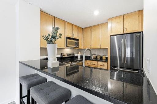 Another view of the kitchen showcasing the stainless steel appliances and generous counter space.
