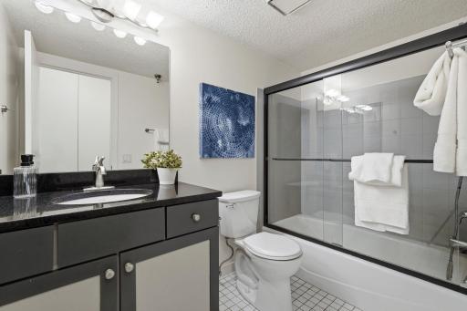 Full bathroom featuring a shower/tub combination and generous vanity area.