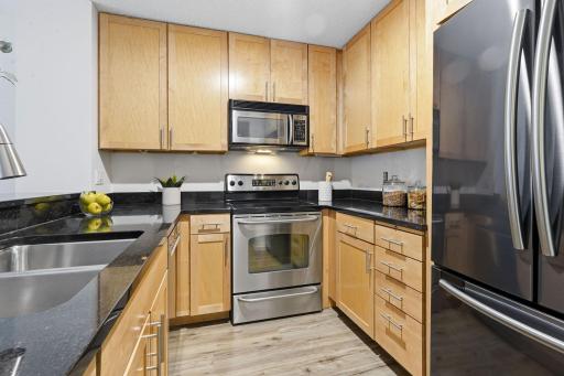 Updated kitchen featuring granite countertops, stainless steel appliances, and ample cabinetry.