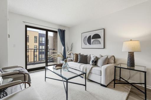 Comfortable living room with wood flooring and direct access to the balcony.