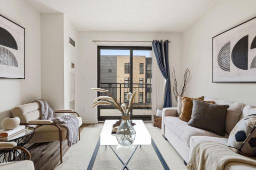 Living area opens to the private balcony, extending the home's entertaining space outdoors.