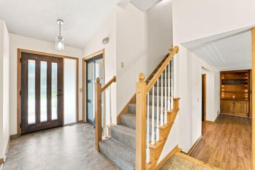 Unique front door, spacious hall closet and stairs leading to the upper level