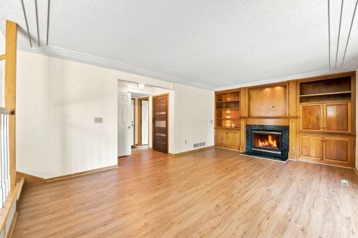 Living room with view into the hall where the laundry room, half bathroom and garage access are