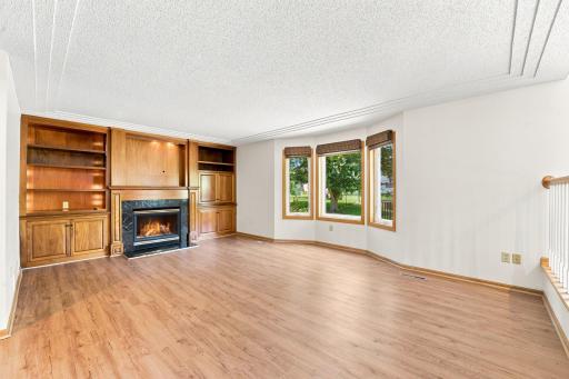 Living room with a bay window, beautiful built ins and a gas burning fireplace