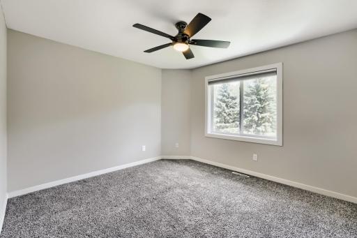 Primary bedroom with ceiling fan and two closets