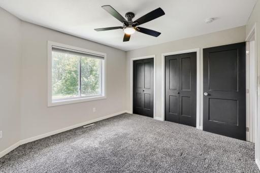Primary bedroom with ceiling fan and two closets