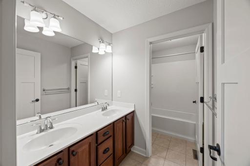 Shared full bathroom is thoughtfully designed for daily function, complemented by an additional walk-in hall closet.