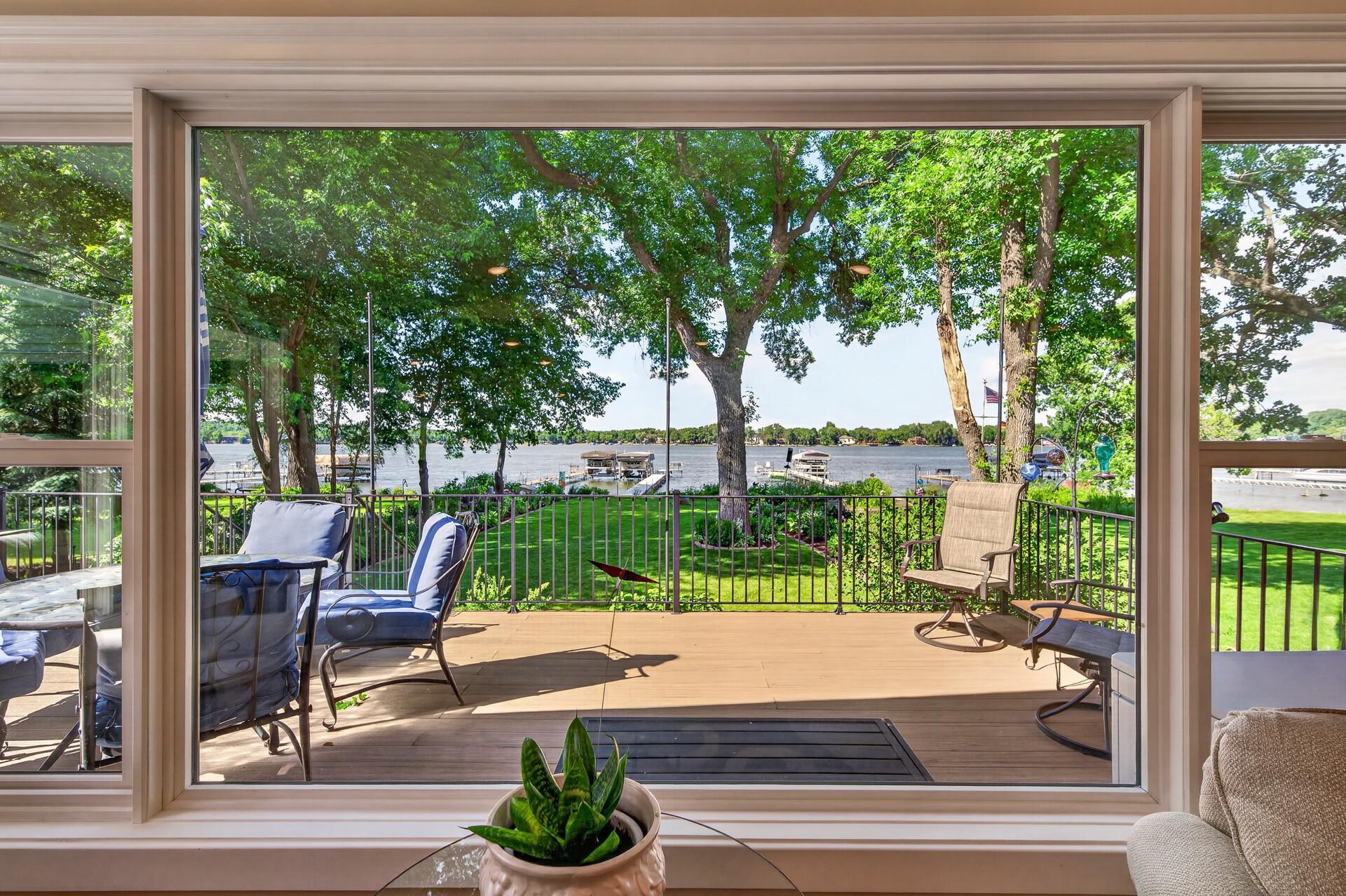 The lake takes center stage through expansive windows overlooking the deck and shoreline.