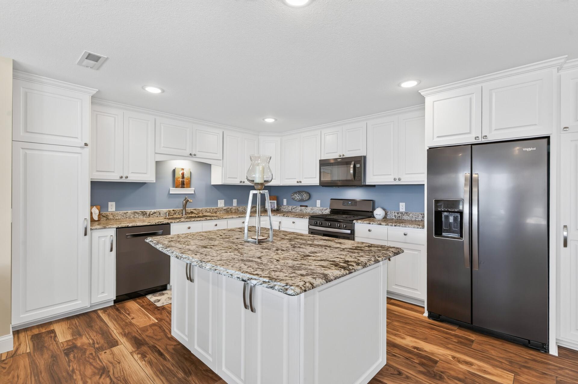 Gather around the oversized island in this beautifully appointed kitchen adorned with black stainless steel appliances.