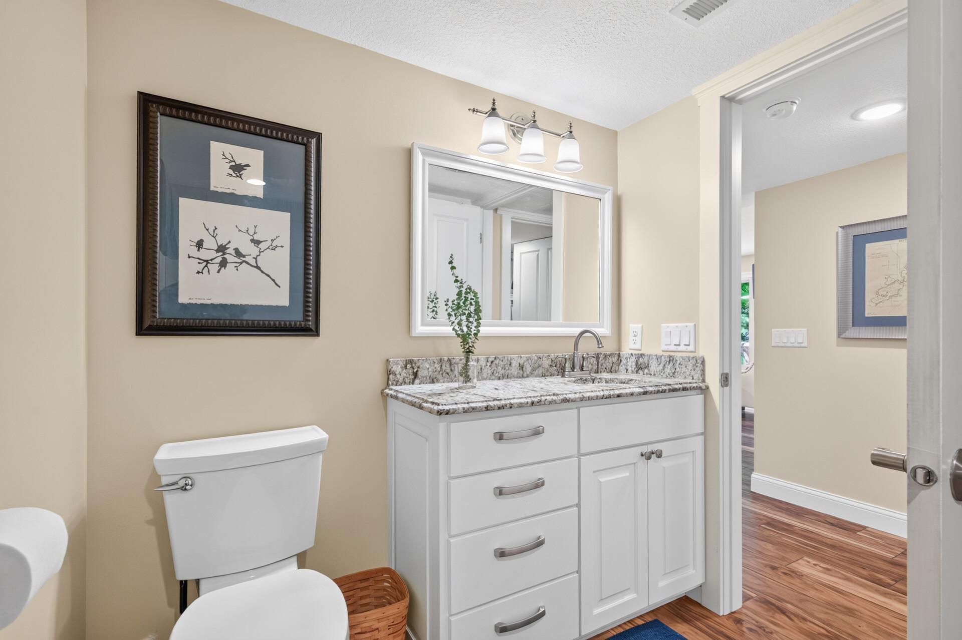 The updated main level three-quarter bathroom offers leathered granite countertops and abundant vanity storage.
