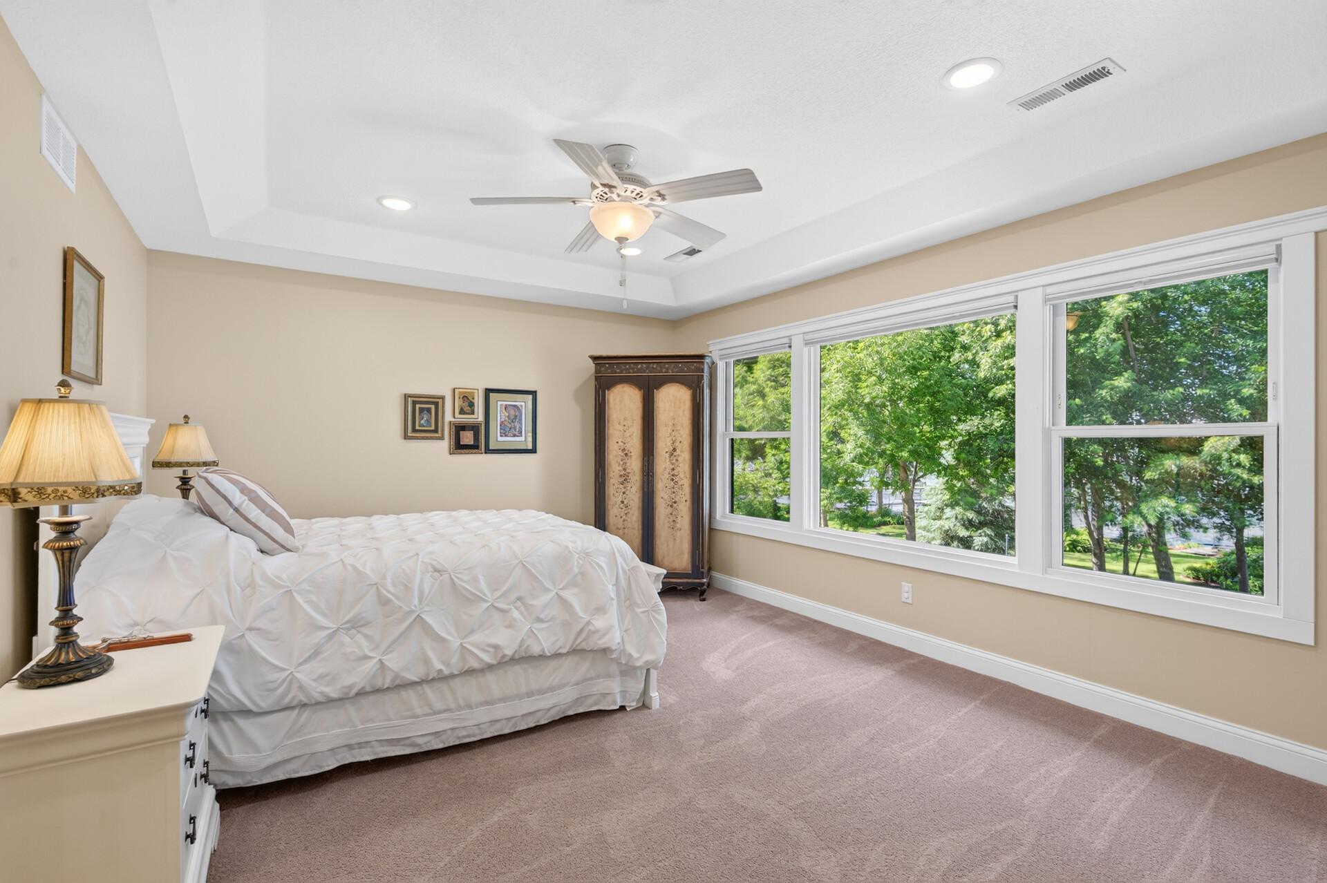 The luxurious primary suite features expansive windows, privacy, and one-of-a-kind views of the lake.