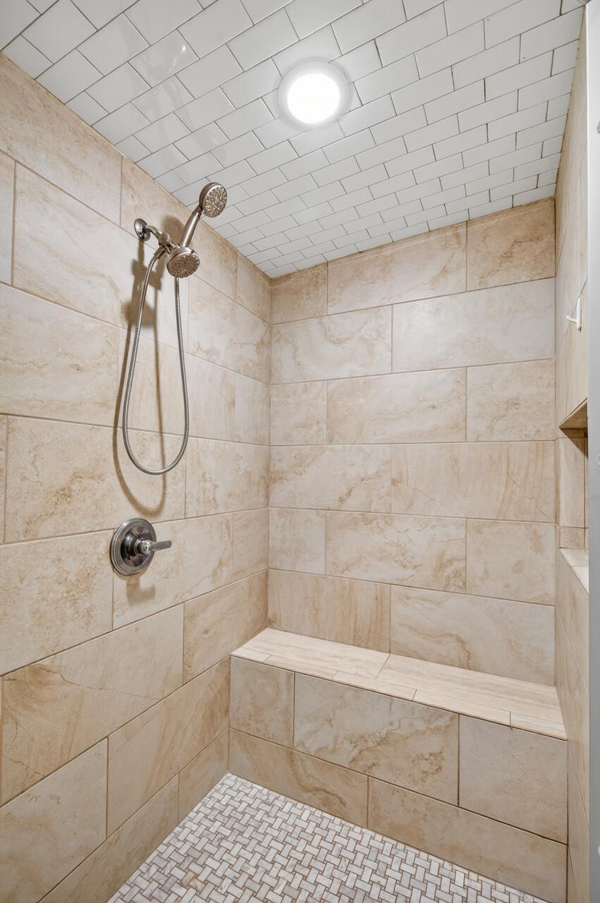 The primary shower offers floor-to-ceiling tile and a built-in bench. This steam shower penetrates tight muscles, decreases stiffness, and can soothe soreness.