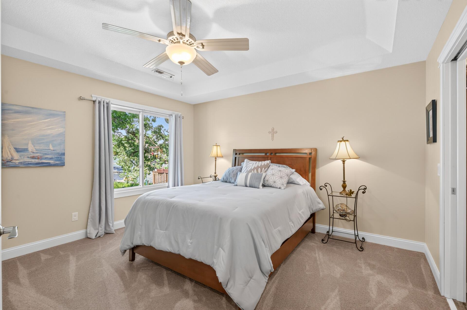 The second bedroom on the upper level offers gorgeous lake views and ample space to relax and unwind. This room also has its own dedicated full bathroom just out of view to the right.