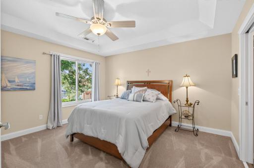 The second bedroom on the upper level offers gorgeous lake views and ample space to relax and unwind. This room also has its own dedicated full bathroom just out of view to the right.
