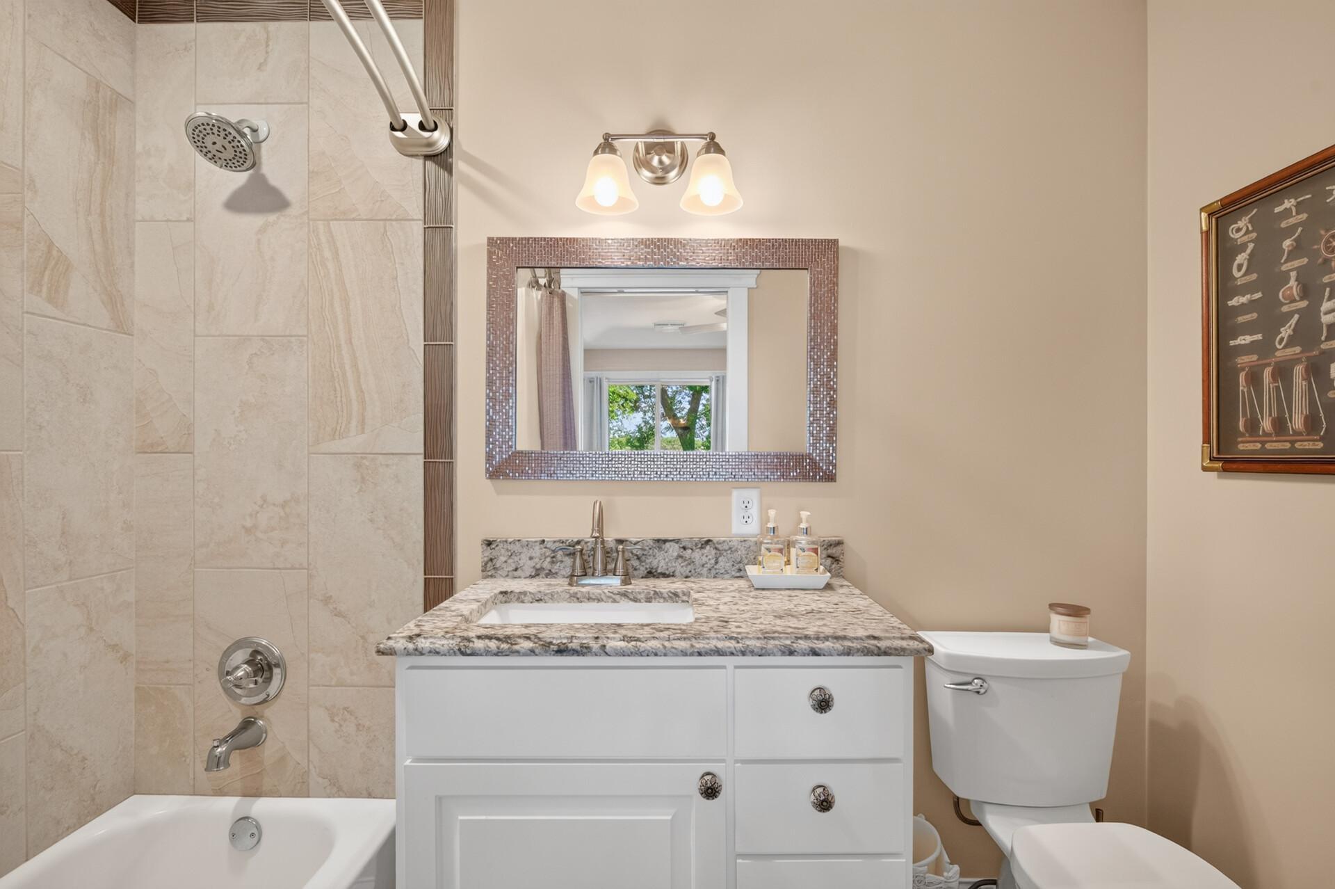 The full bathroom attached to the 2nd bedroom offers leathered granite counters and a beautifully tiled tub surround.