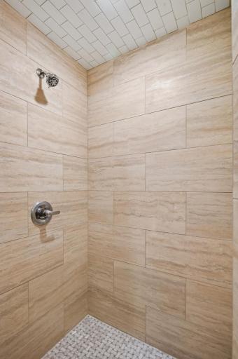 The walk-in shower in the Jack-and-Jill bathroom features floor-to-ceiling tile and timeless, spa-inspired finishes.