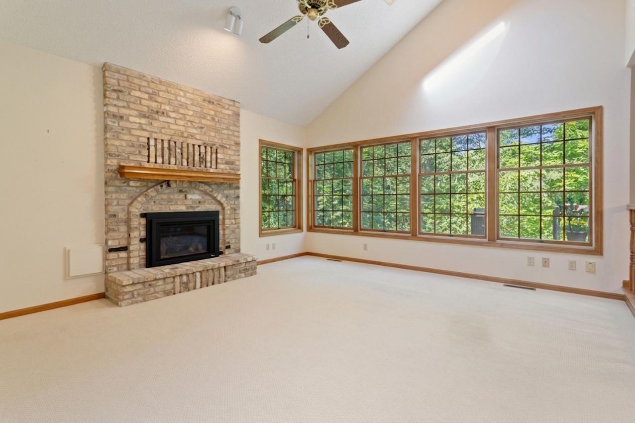 Main level family room, windows overlook wooded ravine lot and setting