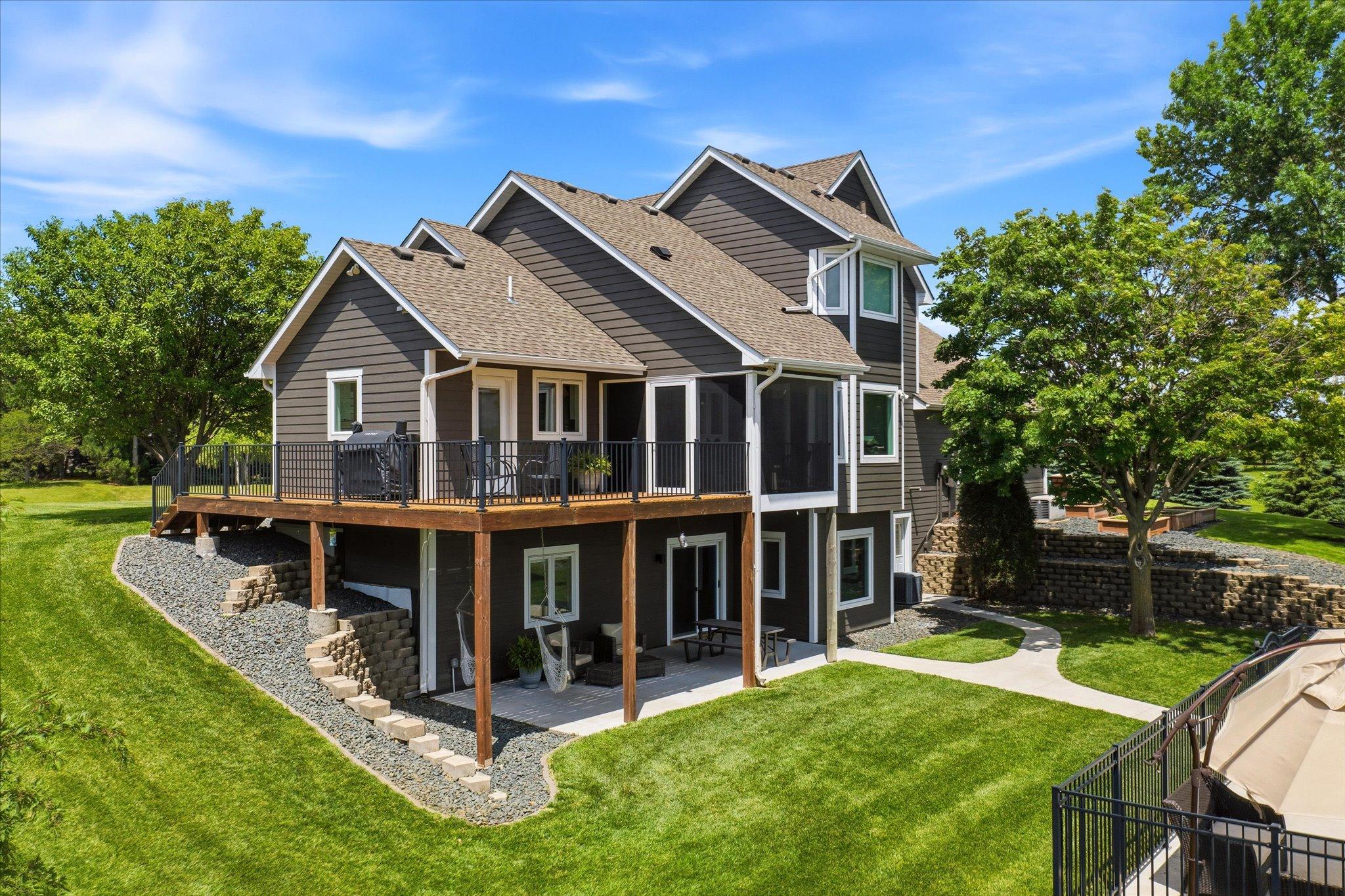 Back view of home with deck/screened in porch, lower level walkout area