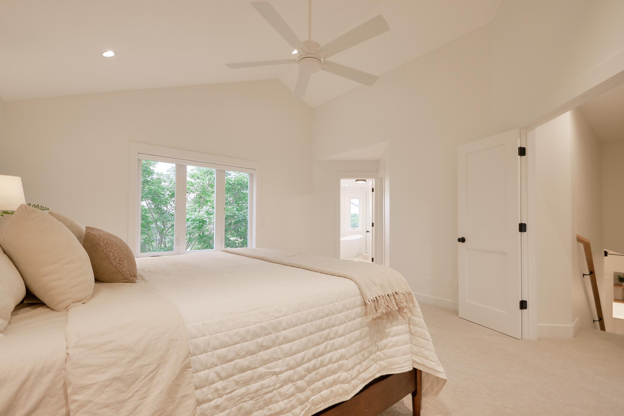 Vaulted ceiling located in primary bedroom