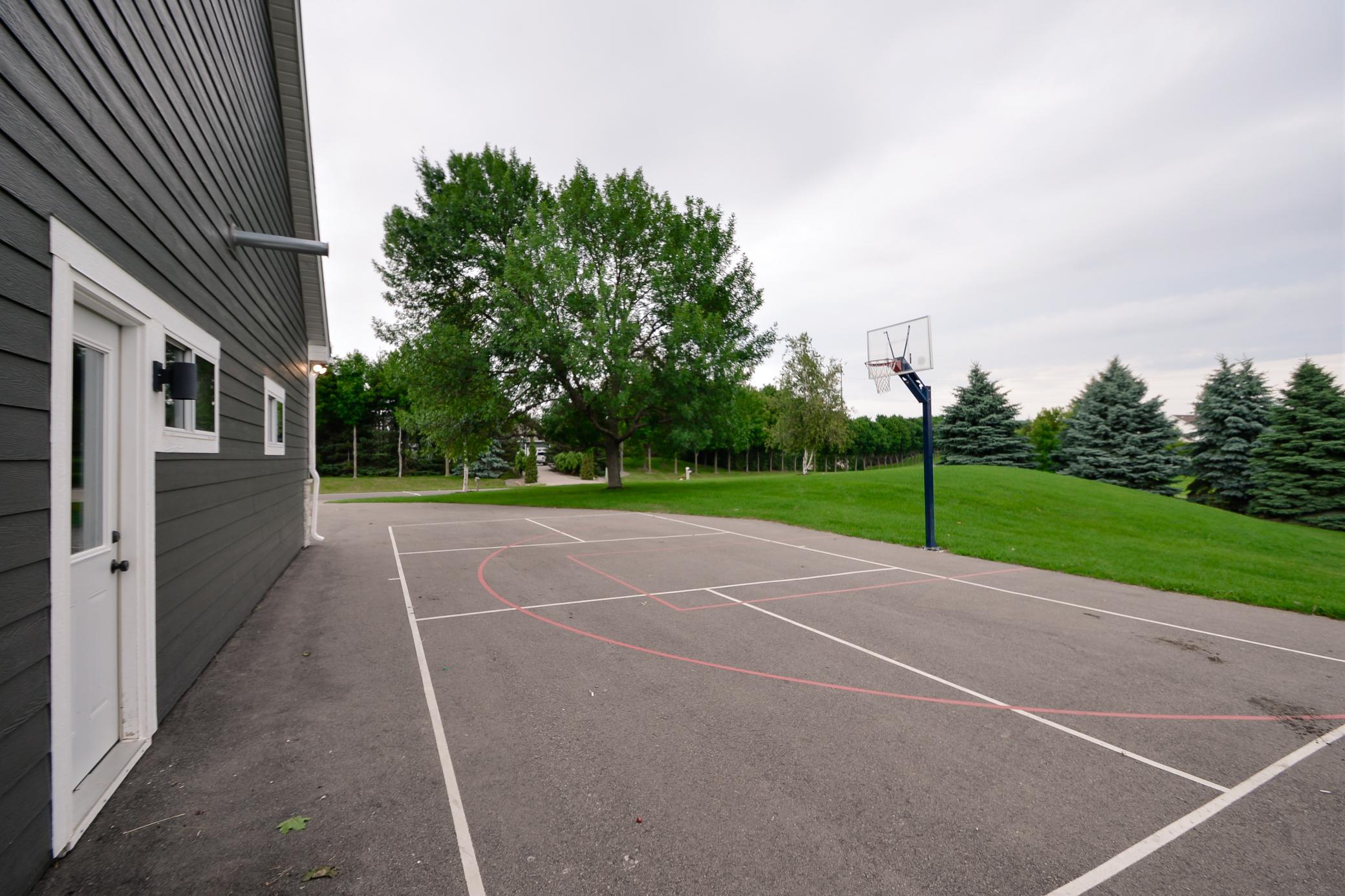 Large outdoor activity area with basketball hoop and painted court