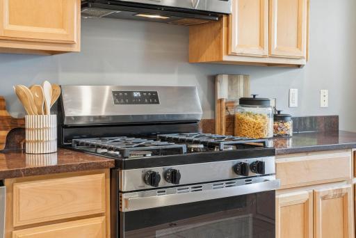 Gas range and abundant cabinetry create a highly functional cooking space.