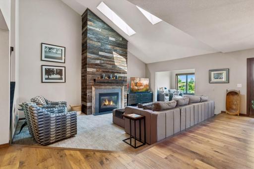 A cozy living space that is highlighted by the natural lighting. The unique surrounding around the fireplace adds character to your living room.