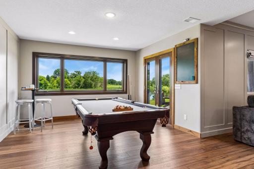 The area in your lower level that shows where you can access your walk-out patio door. This is a perfect spot for a pool table, gaming table, chairs, table, anything you can imagine! These are newer patio doors and an updated concrete patio.