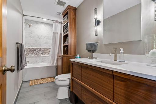 Beautifully updated bathroom that has a custom vanity that has pull out drawers that are great for storage and organization.