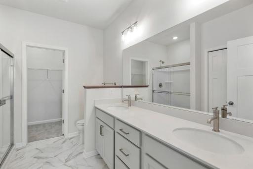 Owner's bathroom with dual sinks, adult height vanity, quartz countertop,