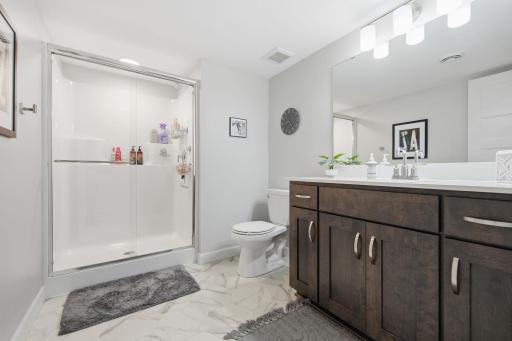 The 3/4 bathroom serves both lower-level bedrooms and communal living areas.