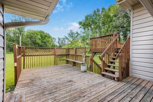Main level deck with stairs to upper level deck and lower level patio