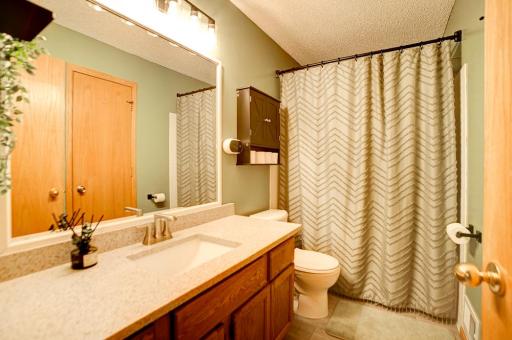 Upper level full bath with jetted tub, updated quartz countertop, sink and faucet and updated tile flooring