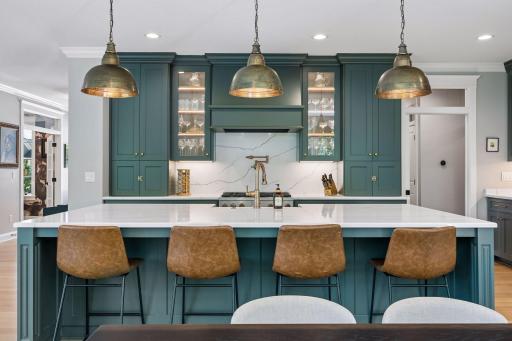Custom illuminated glass cabinetry beautifully showcases collections while adding warmth and architectural character.