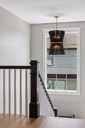 Oversized windows and custom lighting transform the staircase into an architectural focal point.