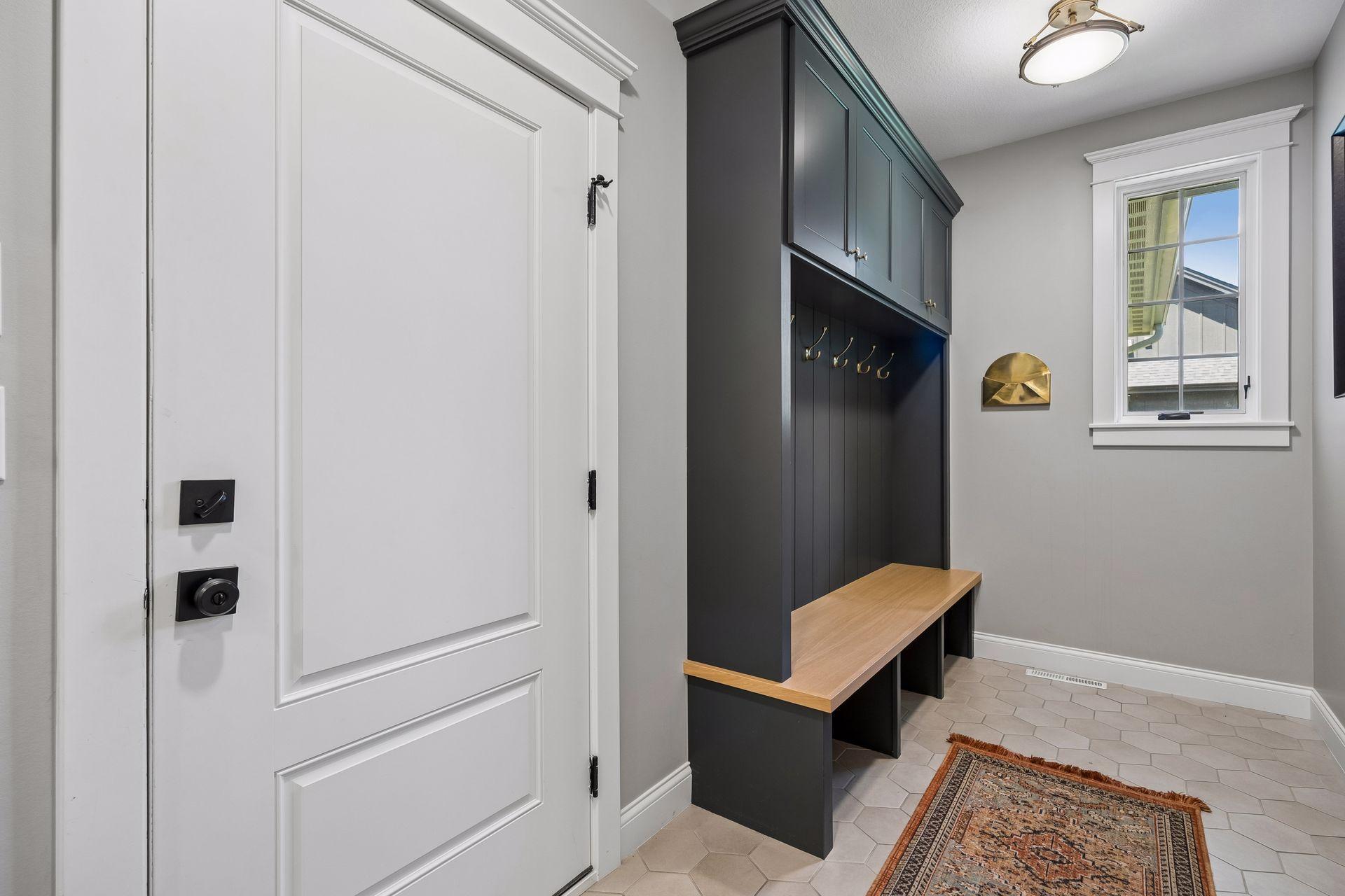 A thoughtfully designed mudroom with custom lockers, built-in bench seating, abundant storage, and timeless finishes for everyday organization.
