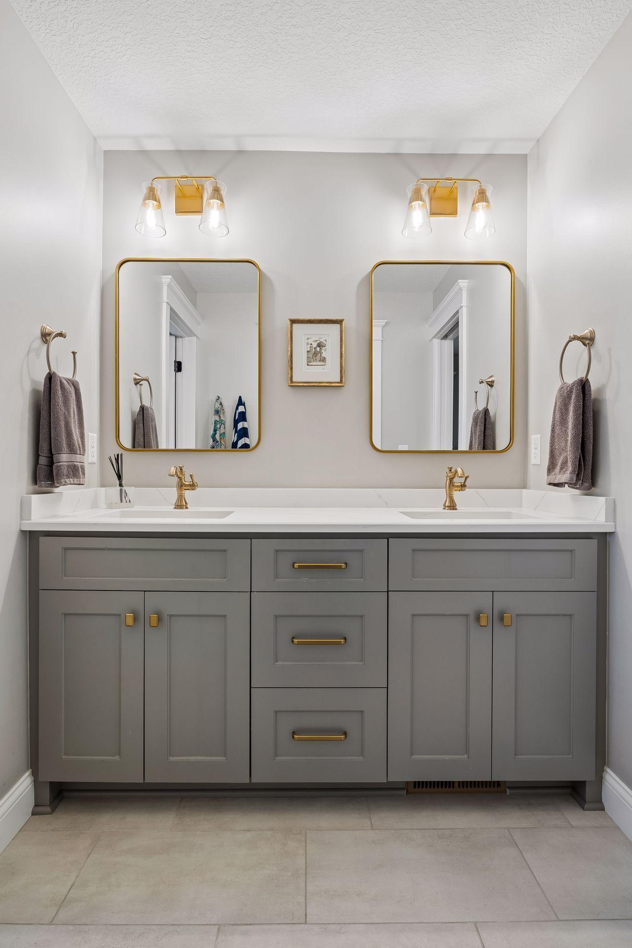 Custom cabinetry, quartz countertops, and elegant brass fixtures elevate this beautifully appointed shared bath.