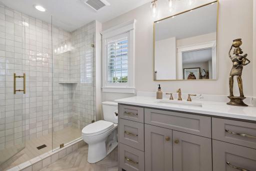 Beautifully tailored with floor-to-ceiling tile, quartz surfaces, and warm brass accents, creating a boutique hotel experience.