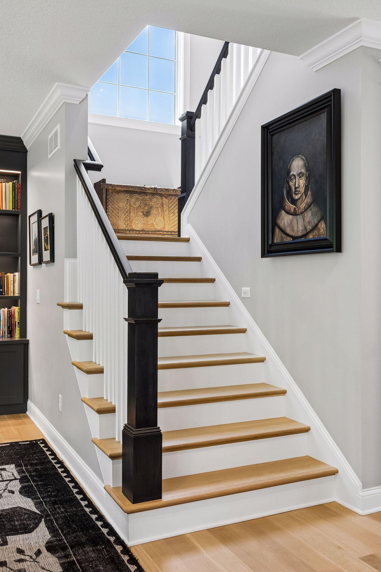 White oak treads, painted risers, and custom millwork create a timeless staircase that anchors the home's architectural design.