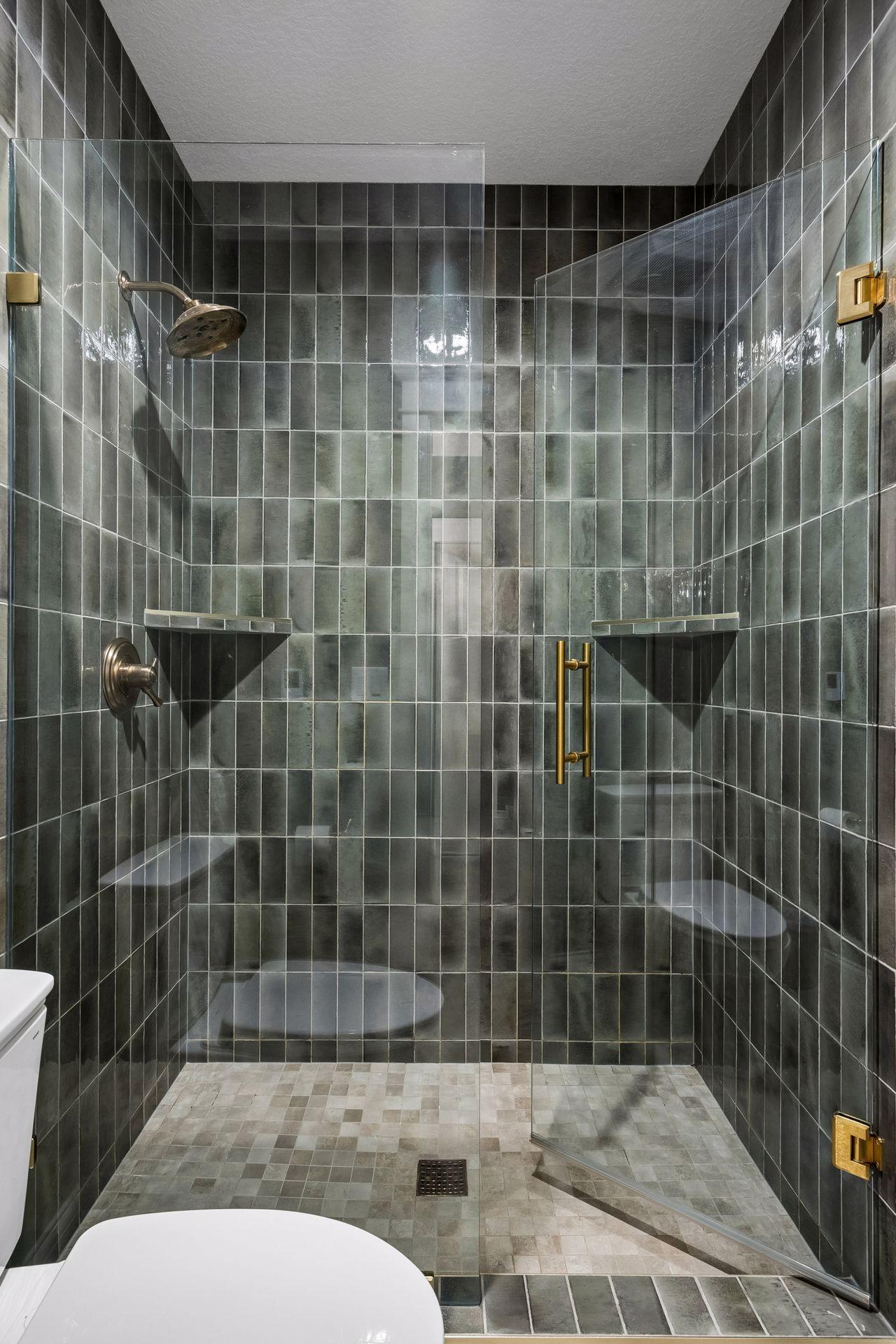 Floor-to-ceiling handcrafted tile and premium fixtures create a luxurious spa-like experience.